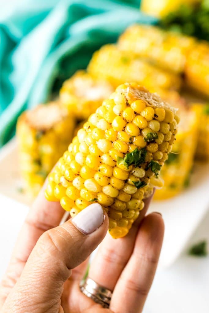 hand holding corn on the cob.