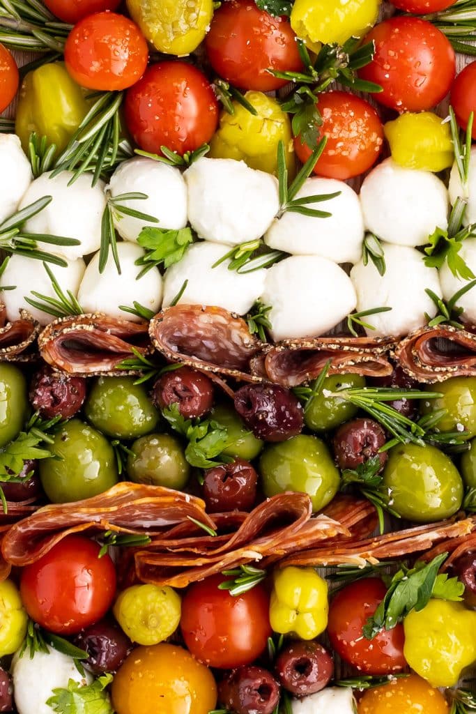 closeup of an antipasto platter with cheeses, olives, and meats.