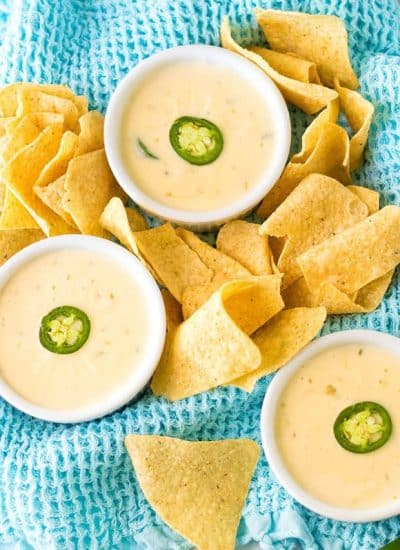 overhead shot of three bowls of queso blanco and tortilla chips.
