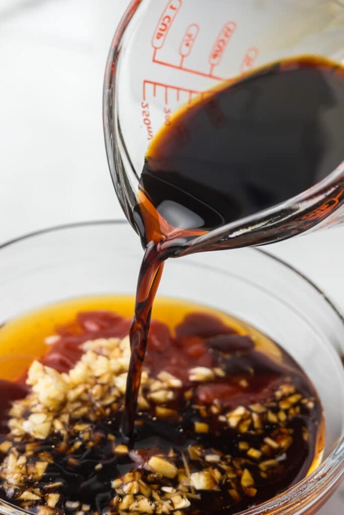 soy sauce pouring into a bowl of sauce.