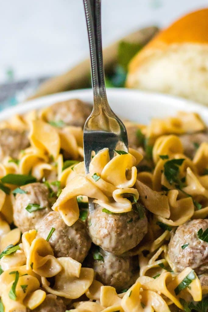fork poking into a bowl of meatball stroganoff.
