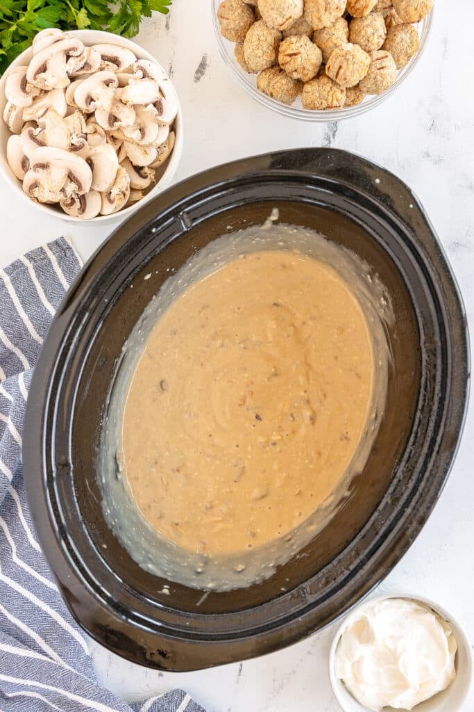 overhead shot of creamy sauce in a slow cooker.