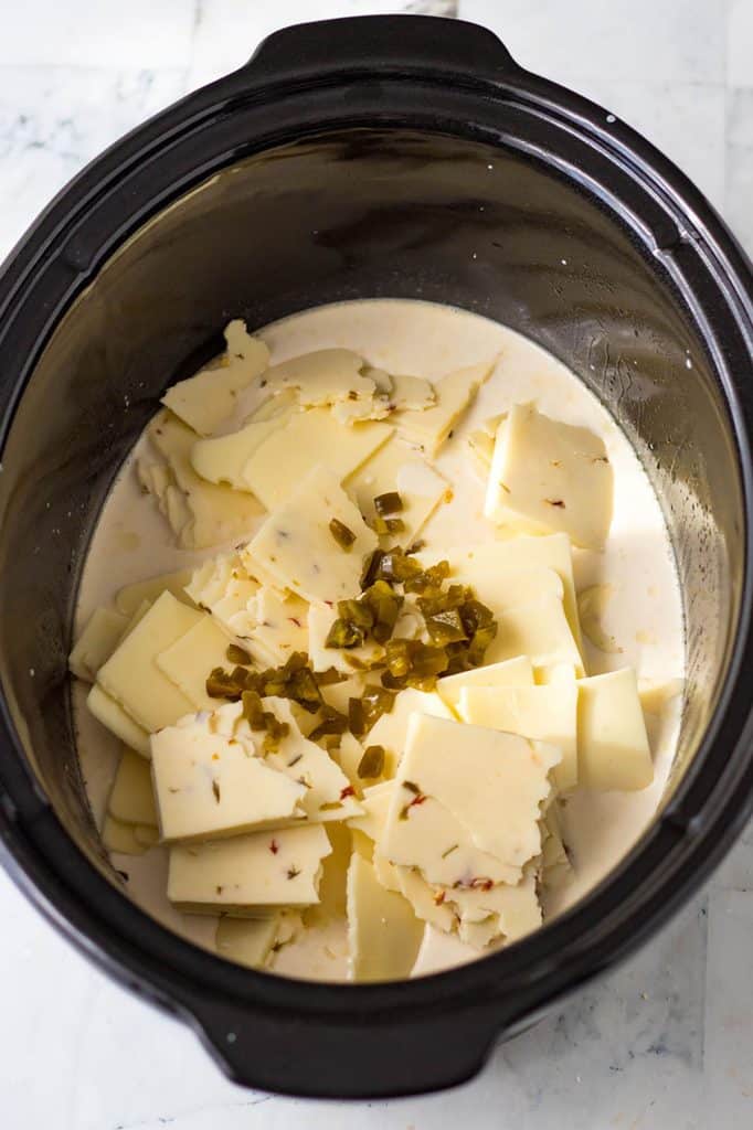 overhead shot of cheese in slow cooker to make queso.