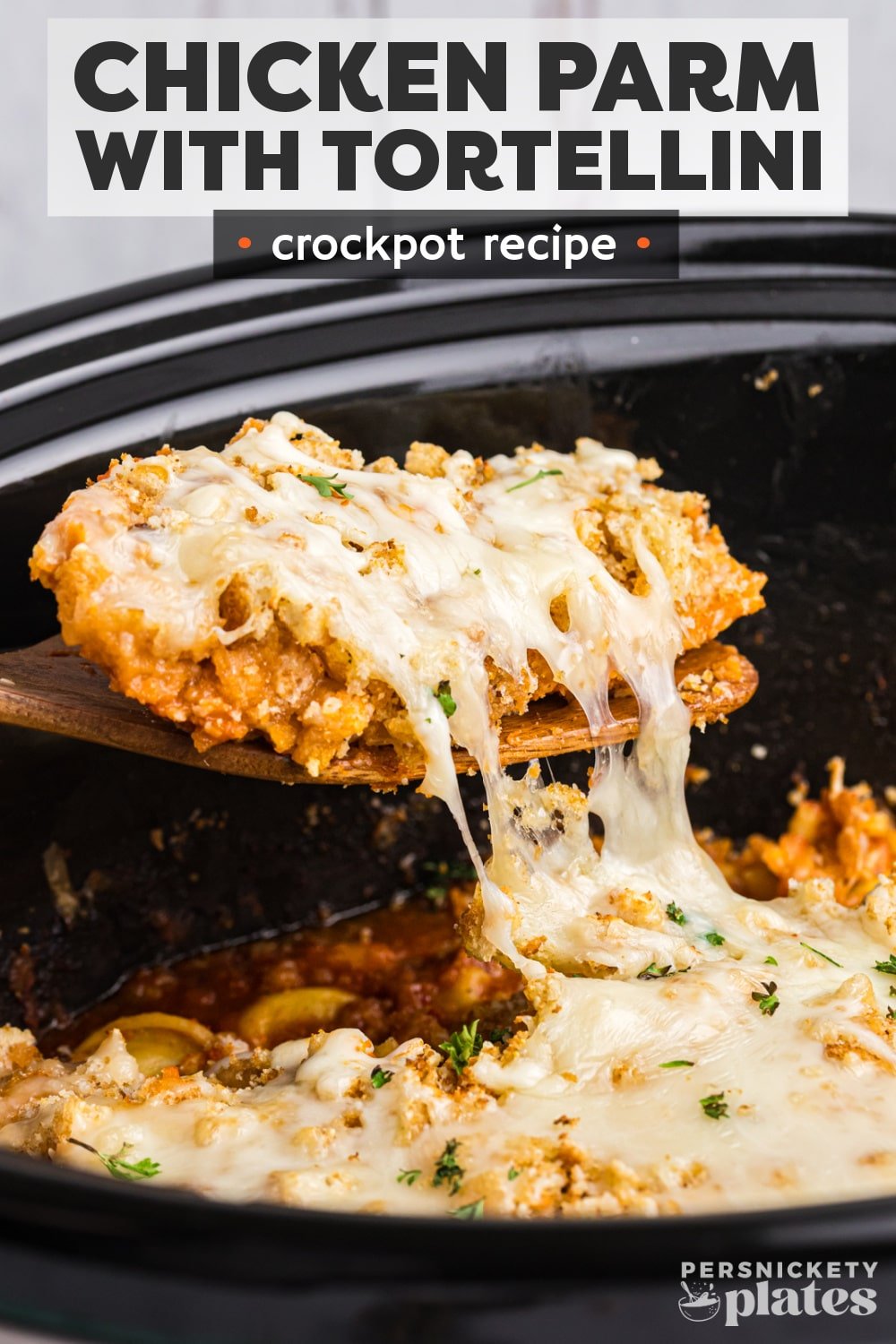 Slow Cooker Chicken Parmesan is a super easy take on a family favorite. Slow cook chicken in your favorite sauce, top with breadcrumbs and cheese, and serve over cheese tortellini. Your entire meal is made right in the slow cooker! | www.persnicketyplates.com