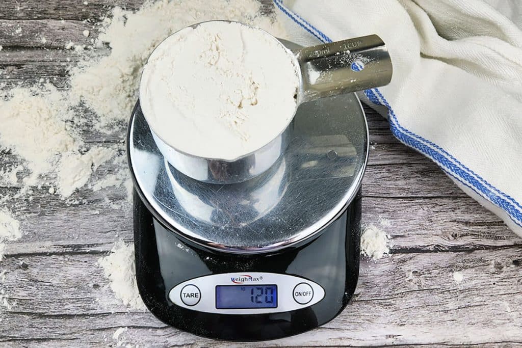 measuring cup of flour on a digital scale.