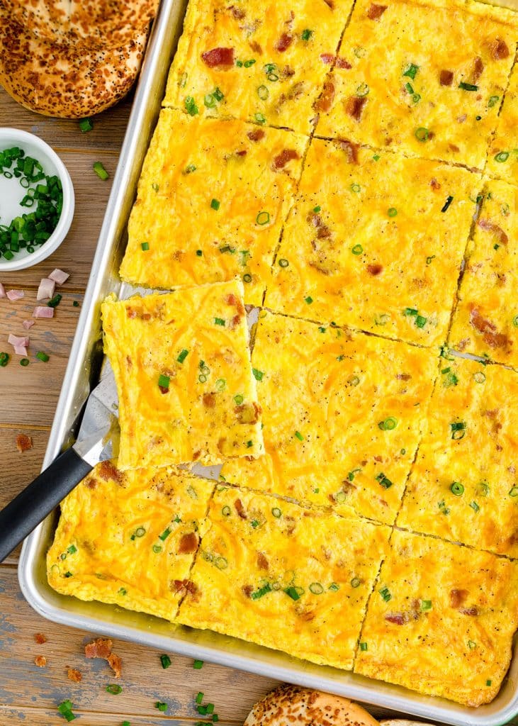 overhead shot of sheet pan eggs with a slice being lifted.