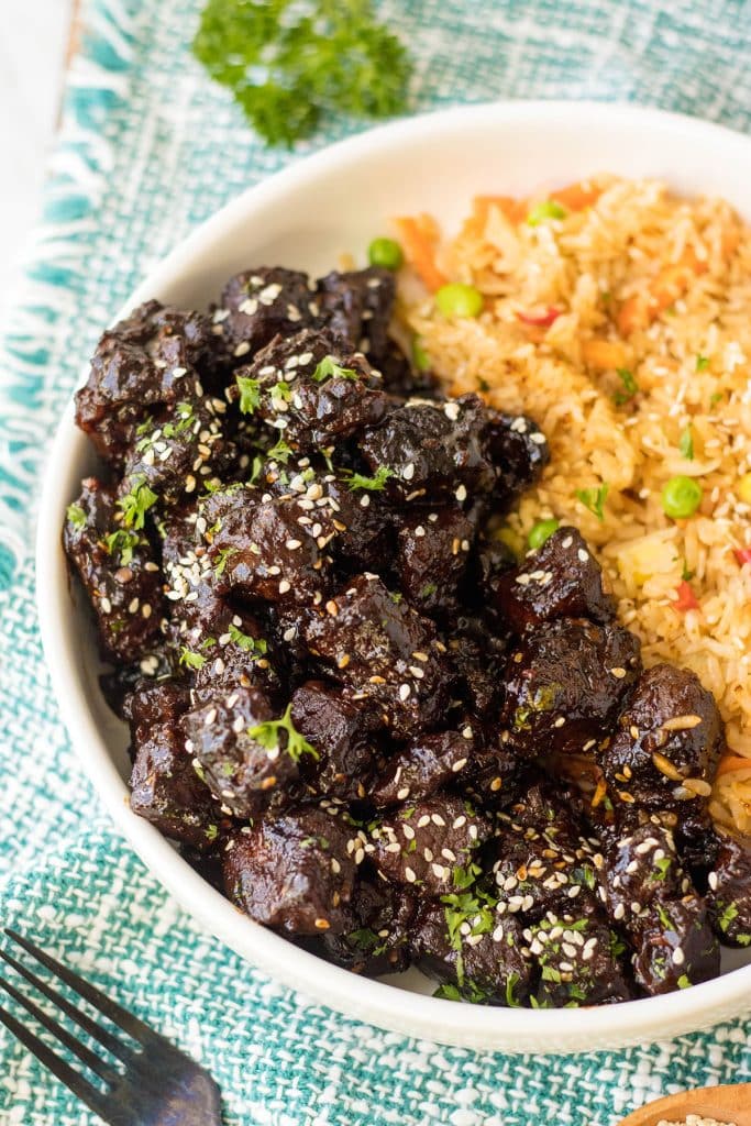 overhead shot of a bowl of honey garlic steak bites with fried rice.