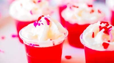 red & pink jello shots with whipped cream and valentine sprinkles.