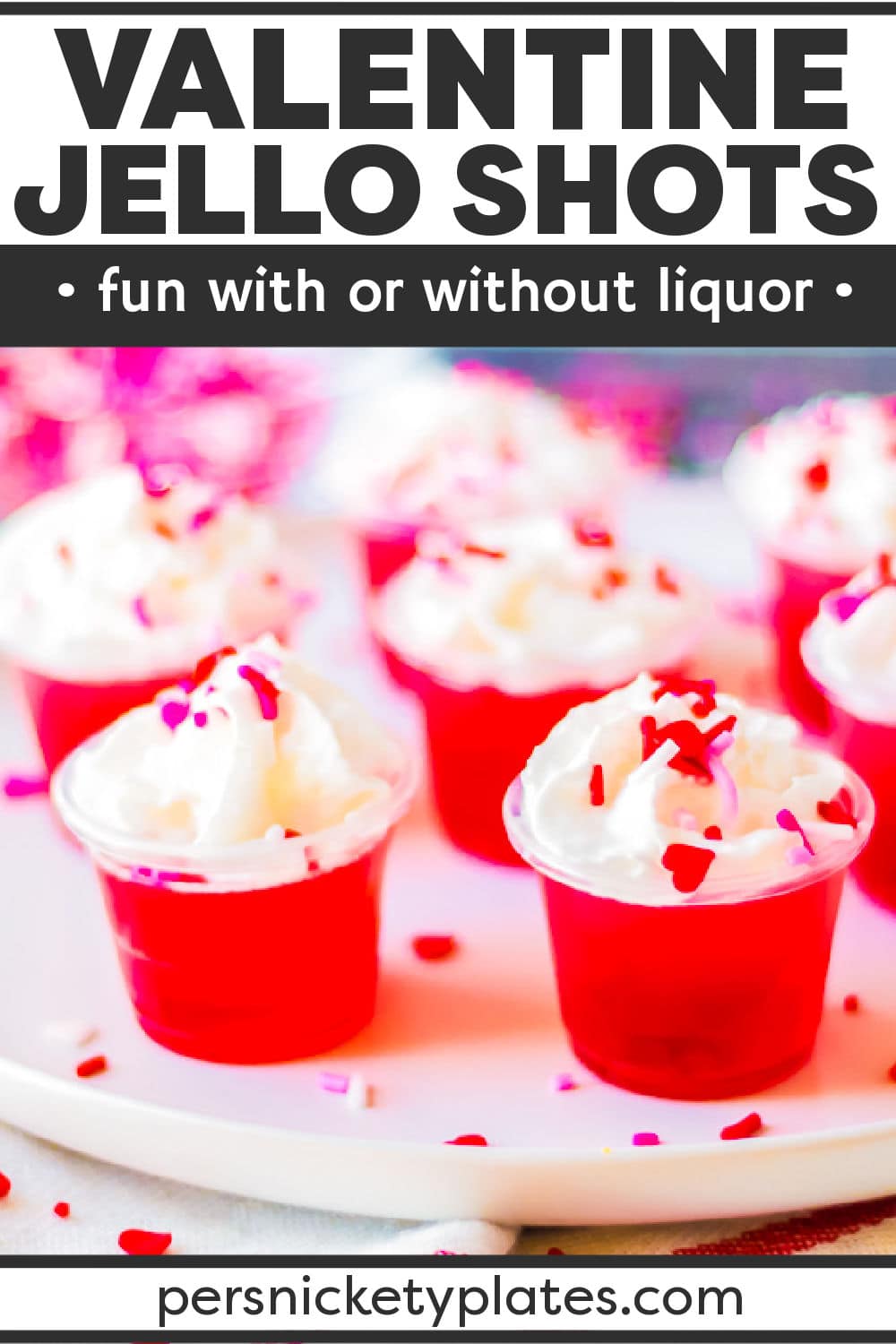 Celebrate Valentine's Day with your loved ones this year with these delicious Valentine's day jello shots! Made with layers of pink and red jello infused with clear vodka (or left non-alcoholic), they couldn't be easier to make. Topped with whipped cream and sprinkles, these irresistible jello shots are always a hit! | www.persnicketyplates.com