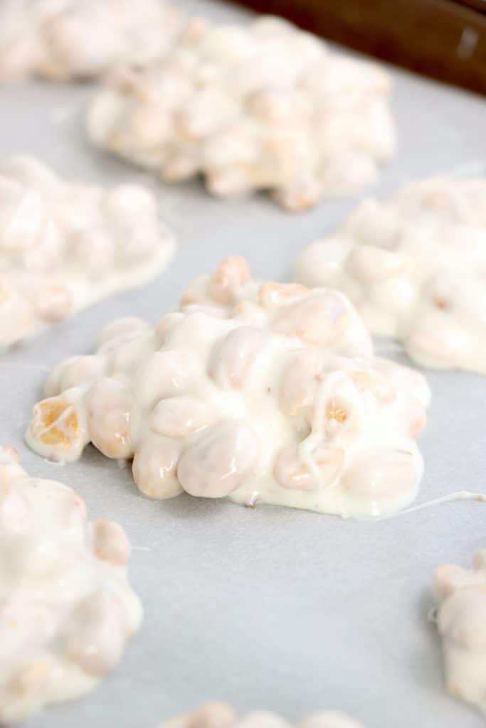 white chocolate peanut cluster on parchment paper.