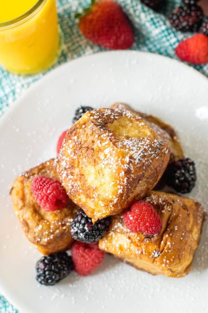 overhead shot of french toast on a white plate.