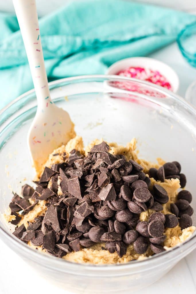 bowl of cookie dough topped with chopped chocolate.