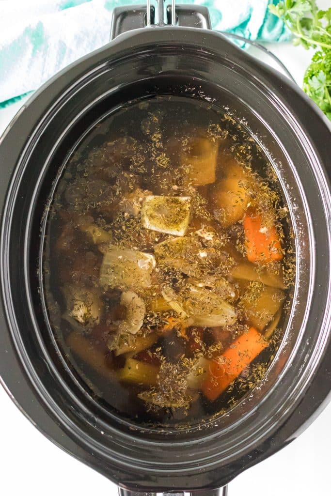 overhead shot of chicken stock in a slow cooker.