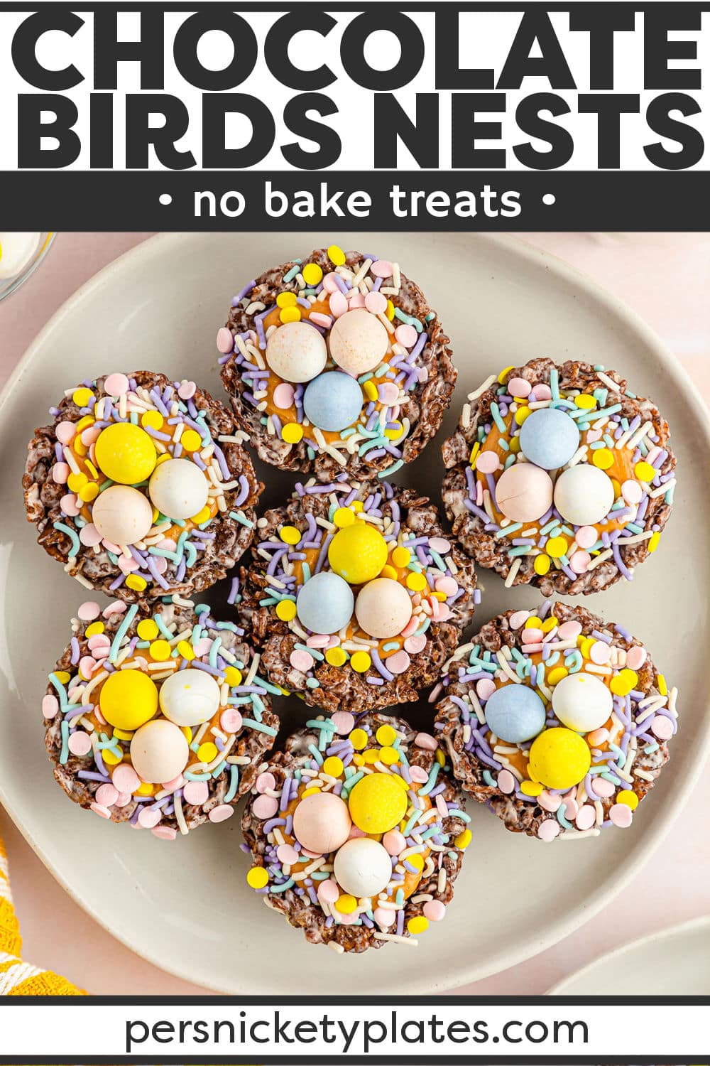 No Bake Chocolate Peanut Butter Birds Nest Cookies are a fun Easter treat made with marshmallow and cocoa pebbles for the nest, peanut butter for the filling, and mini eggs for the final touch. These bird's nest cookies are a must-make this year! | www.persnicketyplates.com