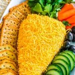 carrot shaped cheese ball on a platter with veggies and crackers.