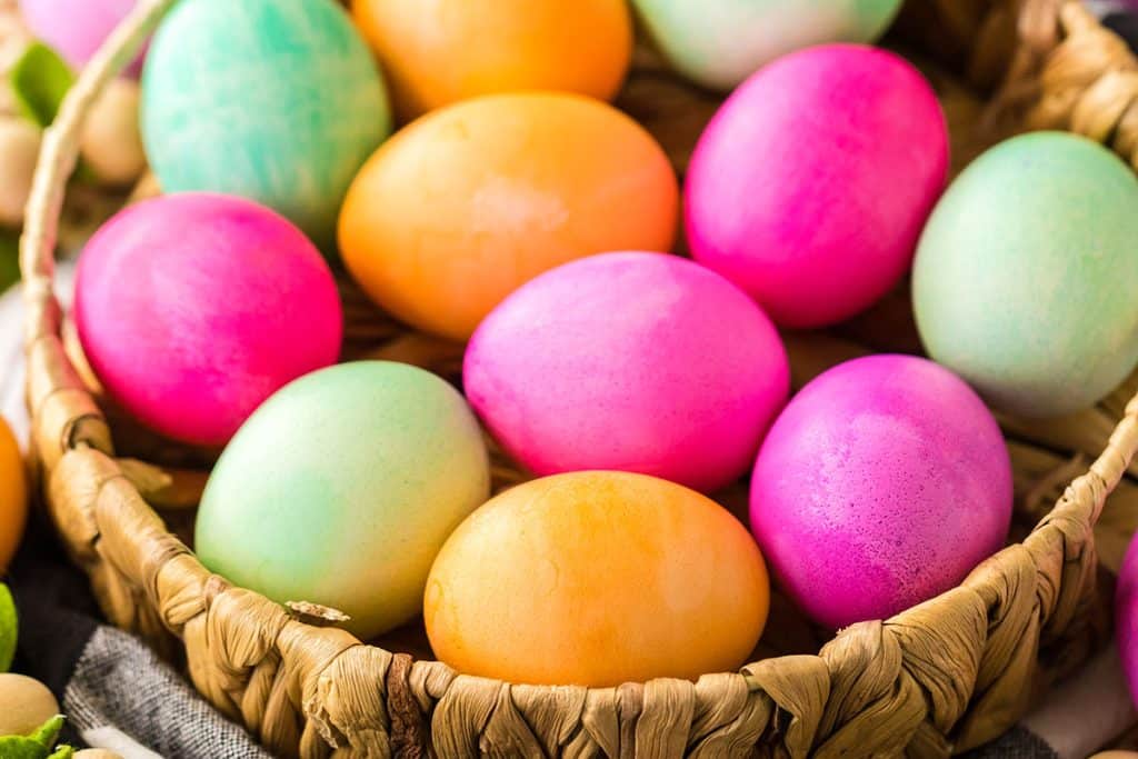 wicker basket filled with colorful easter eggs.