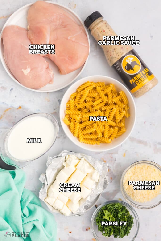 overhead shot of labeled ingredients laid out to make garlic parmesan chicken pasta.