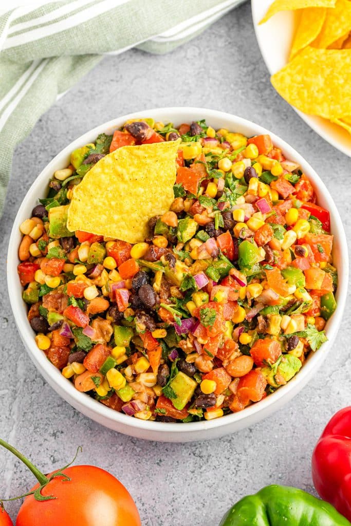 bowl of cowboy caviar dip with a chip stuck in it.