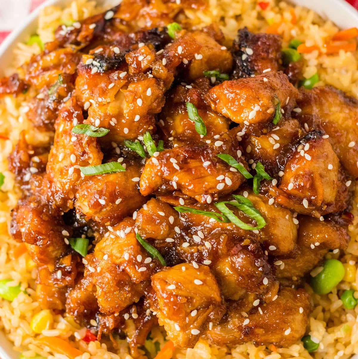 overhead shot of orange chicken on a bed of fried rice.