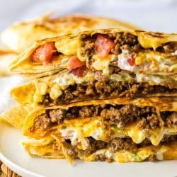stack of cut crunchwrap supremes on a white plate.