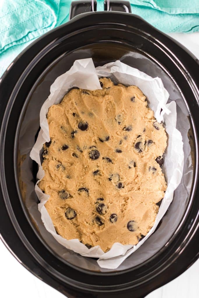 overhead shot of chocolate chip cookie dough in a crockpot.
