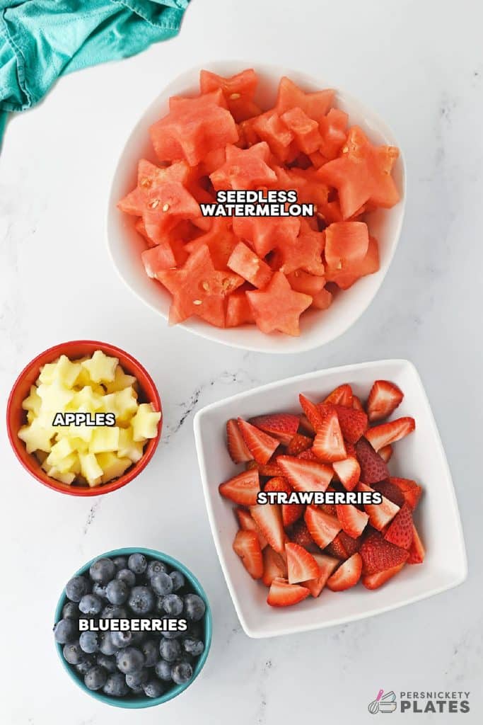 overhead shot of labeled ingredients laid out to make fruit salad.