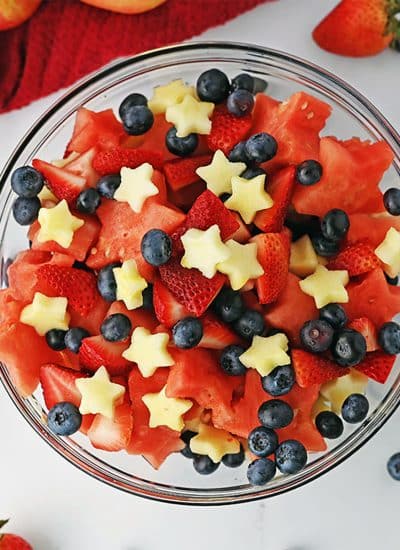 overhead shot of a bowl of fruit salad with apple stars.