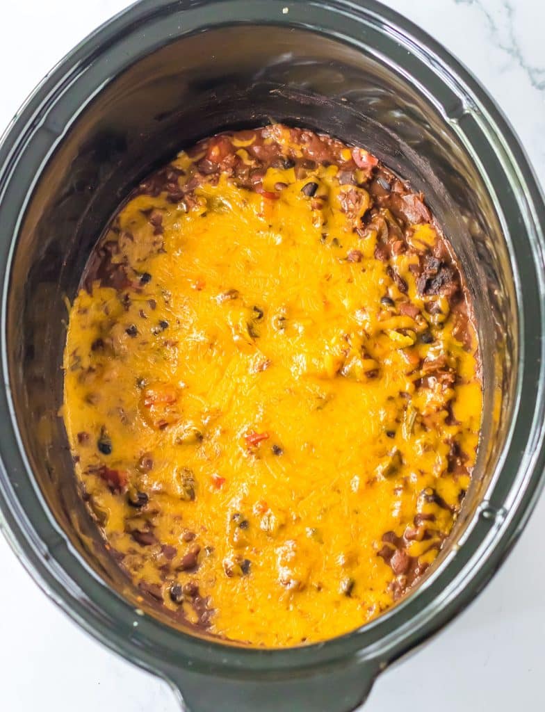 melted cheese on chili in a slow cooker.