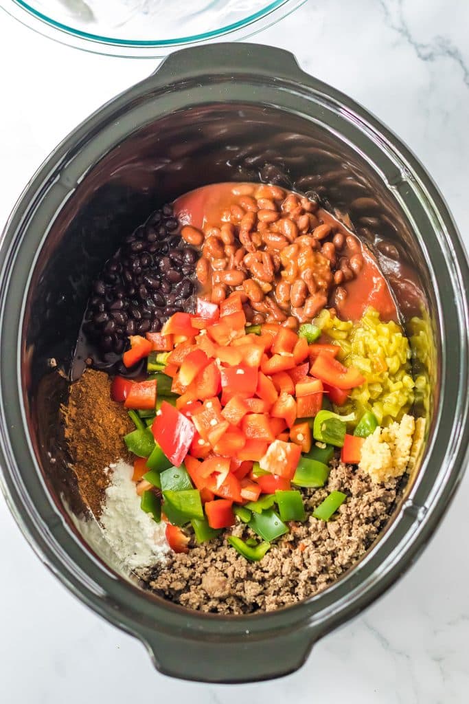 overhead shot of chili ingredients in a slow cooker.
