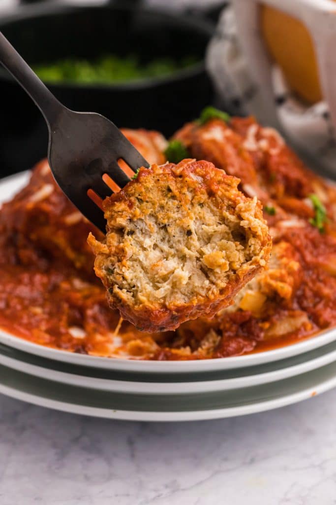 fork sticking into a chicken parmesan meatball.