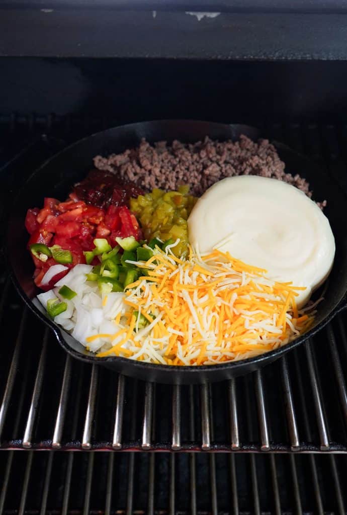 skillet of ingredients in a smoker to make queso.