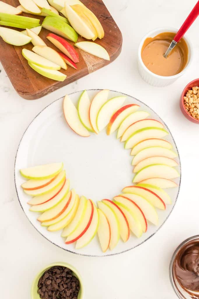 apple slices being arranged in a circle on a platter.