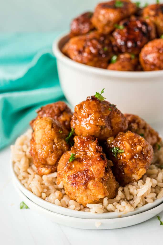 firecracker meatballs on top of a plate of rice.