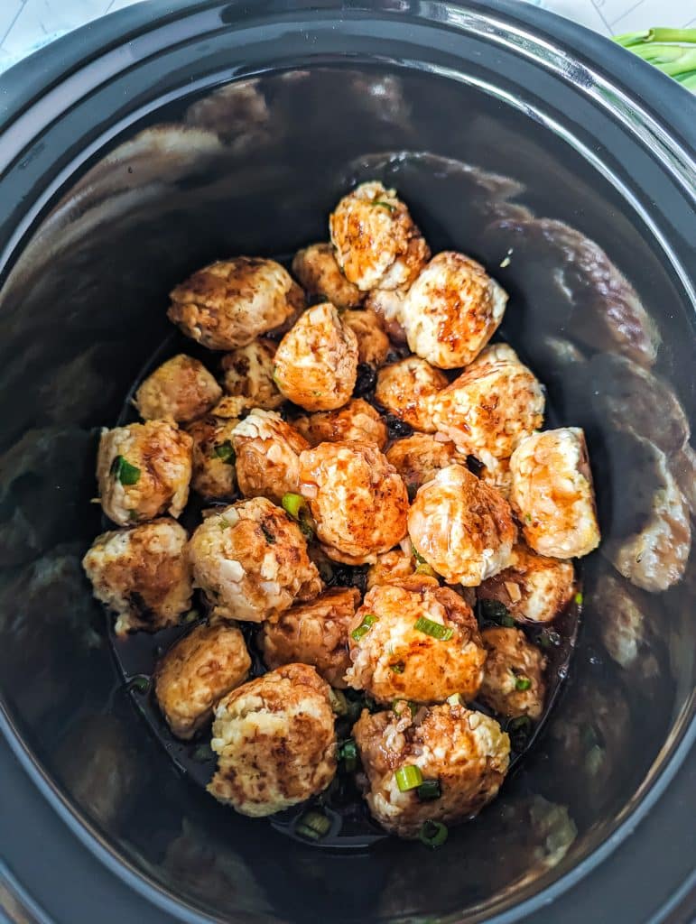 chicken meatballs covered in sauce in a crockpot.