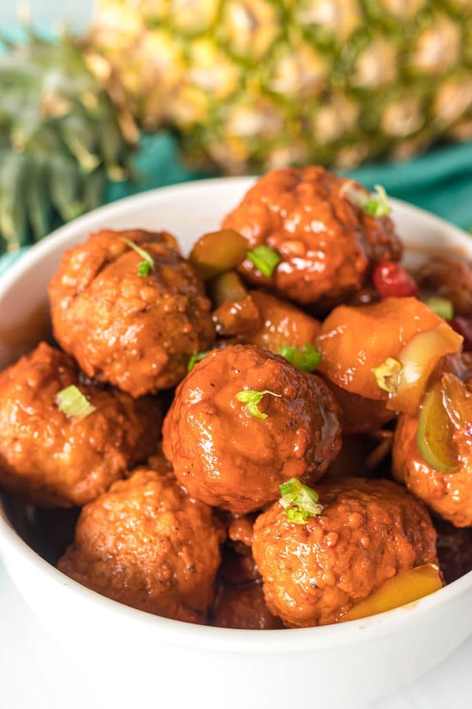 bowl of hawaiian meatballs topped with scallions.