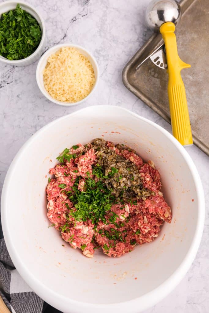 overhead shot of raw meatball mixture in a mixing bowl.
