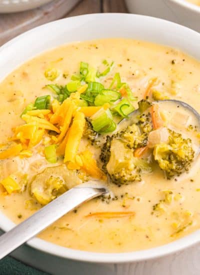 bowl of broccoli cheddar soup with a spoon in it.