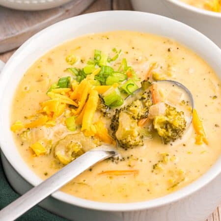 bowl of broccoli cheddar soup with a spoon in it.