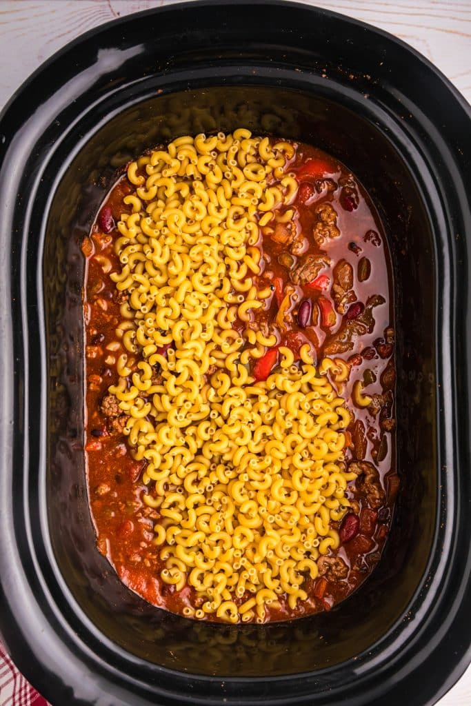 uncooked elbow macaroni in slow cooker chili.