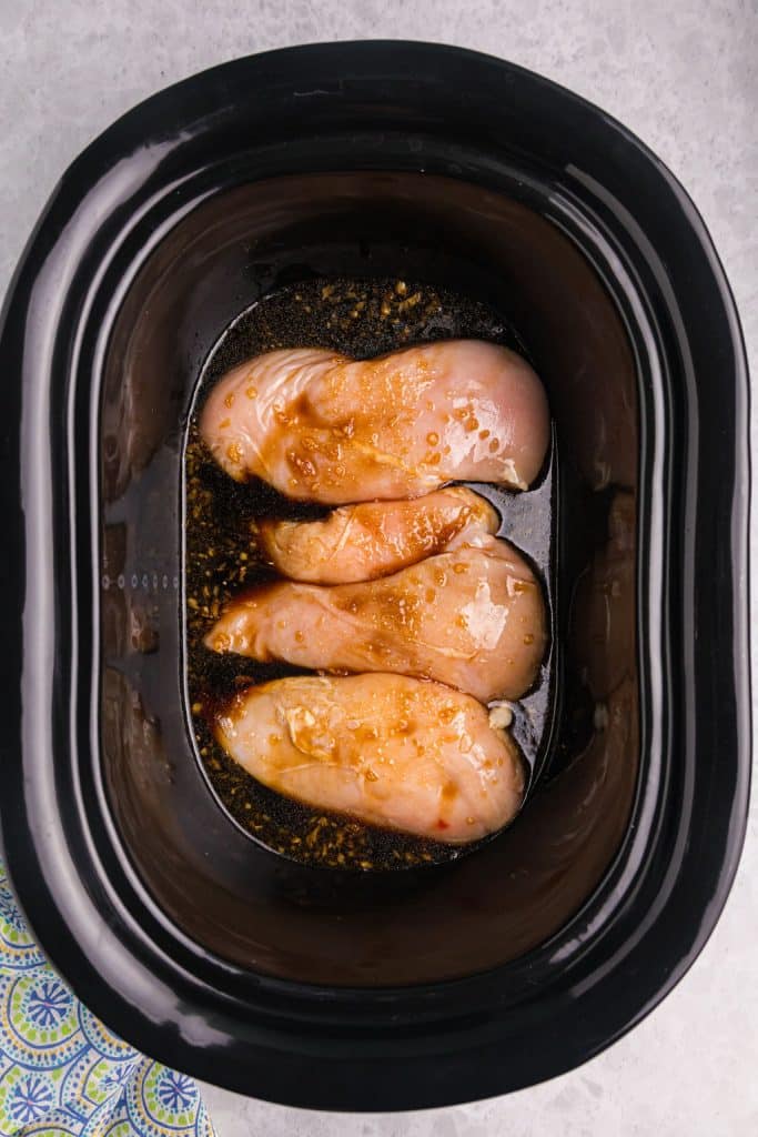 overhead shot of chicken covered in teriyaki sauce in a crockpot.