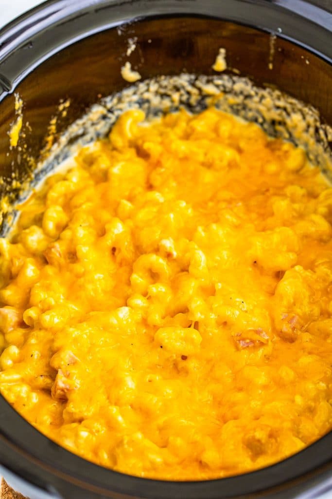 overhead shot of mac and cheese with ham in a slow cooker.