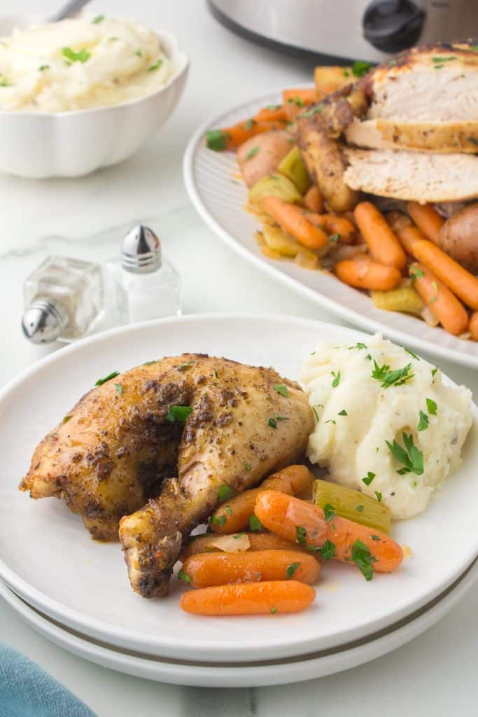 plate with chicken quarter, carrots, and mashed potatoes.