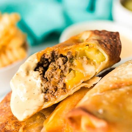 cheeseburger egg roll sliced in half dipped in special sauce.