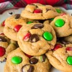 pile of chocolate chip cookies with red & green M&Ms for christmas.