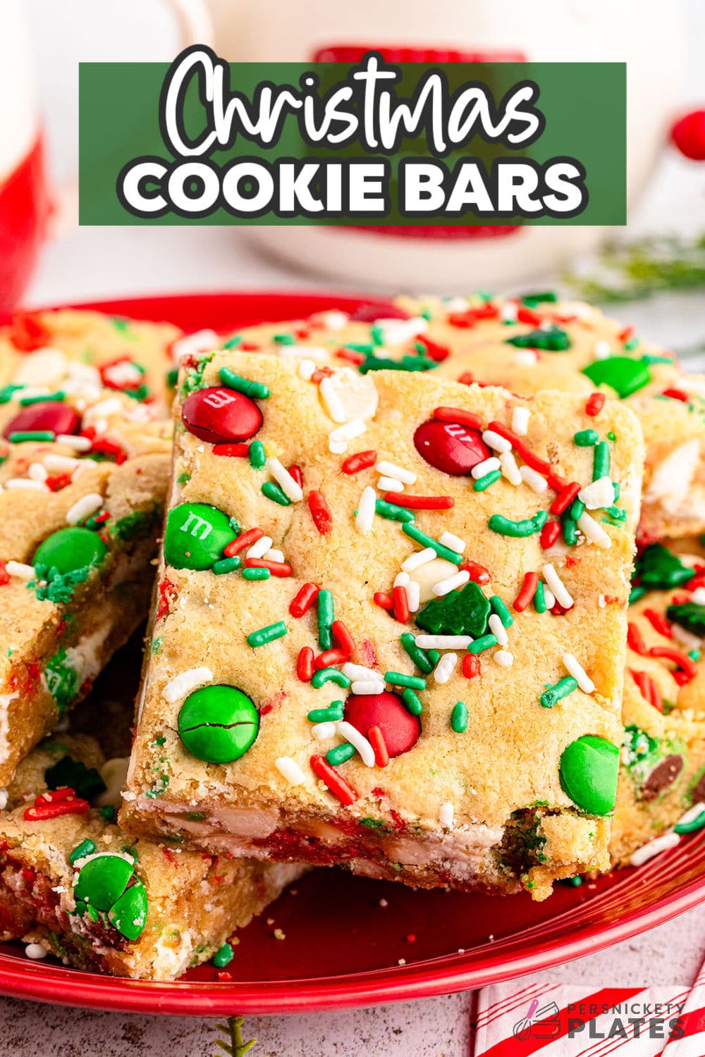 So much faster than drop cookies and just as festive, these tasty and decadent Christmas cookie bars have a chewy cookie base and are loaded with festive M&Ms and white chocolate chips. They are a must-make during the busy holiday season! | www.persnicketyplates.com