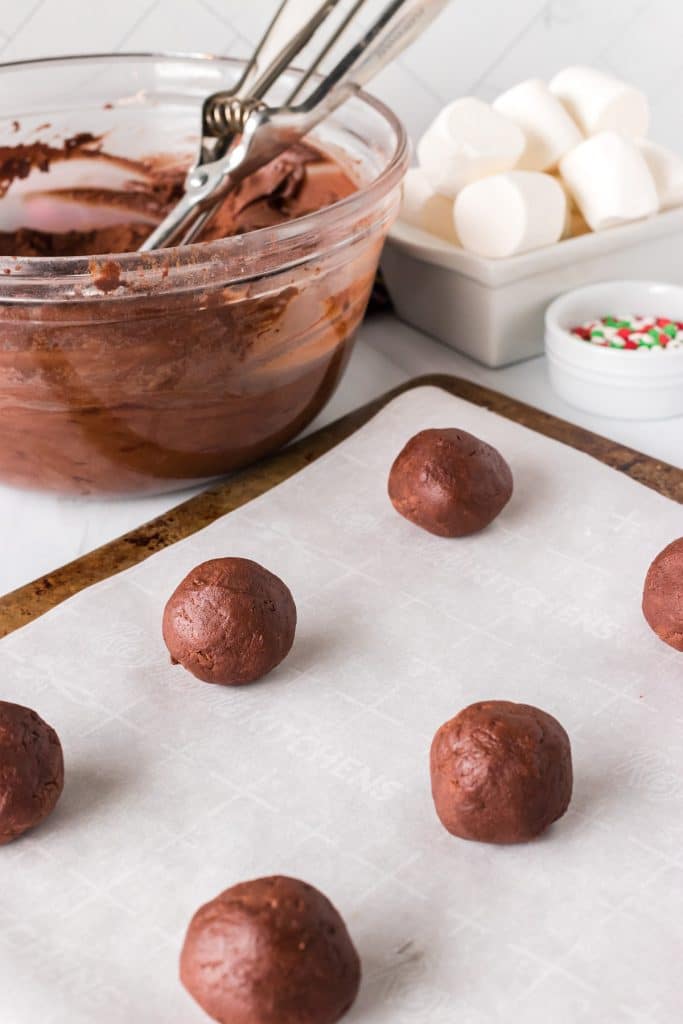 chocolate cookie dough balls on a baking sheet.