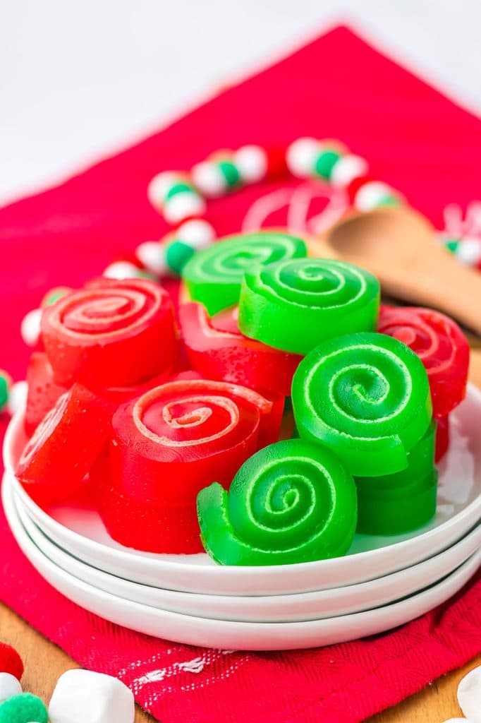 plate of christmas jello roll ups on a red napkin.