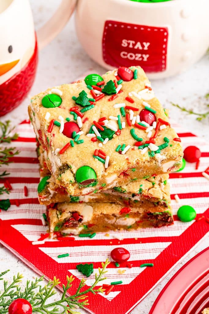stack of M&M christmas cookie bars on a striped napkin.