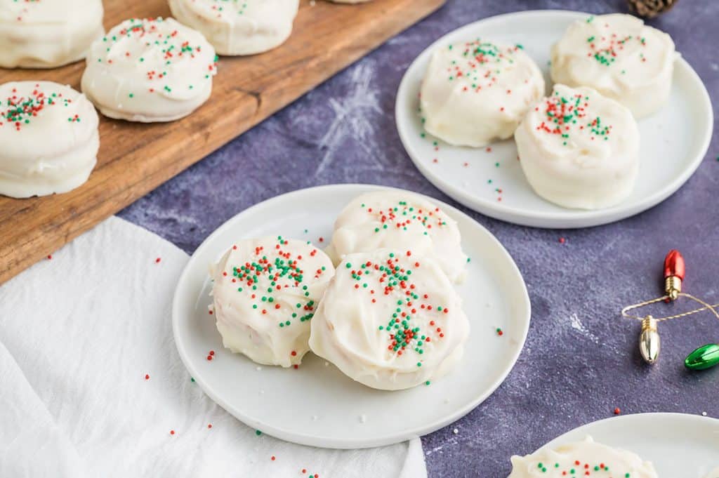 white chocolate ritz cookies with christmas sprinkles on white plates.