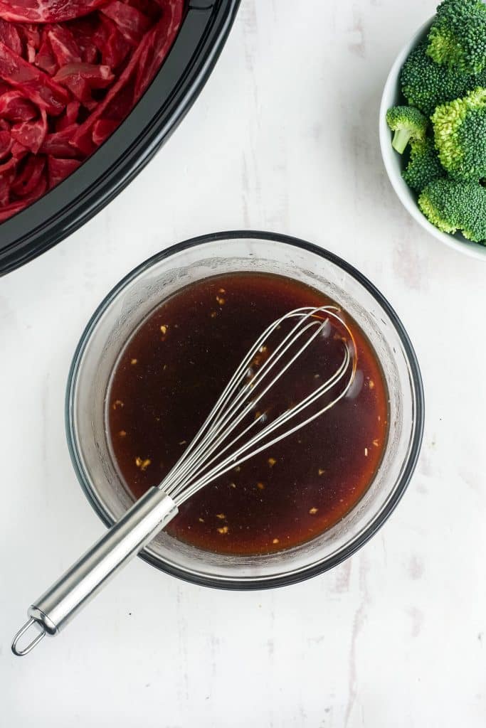 bowl of sauce with a whisk in in.